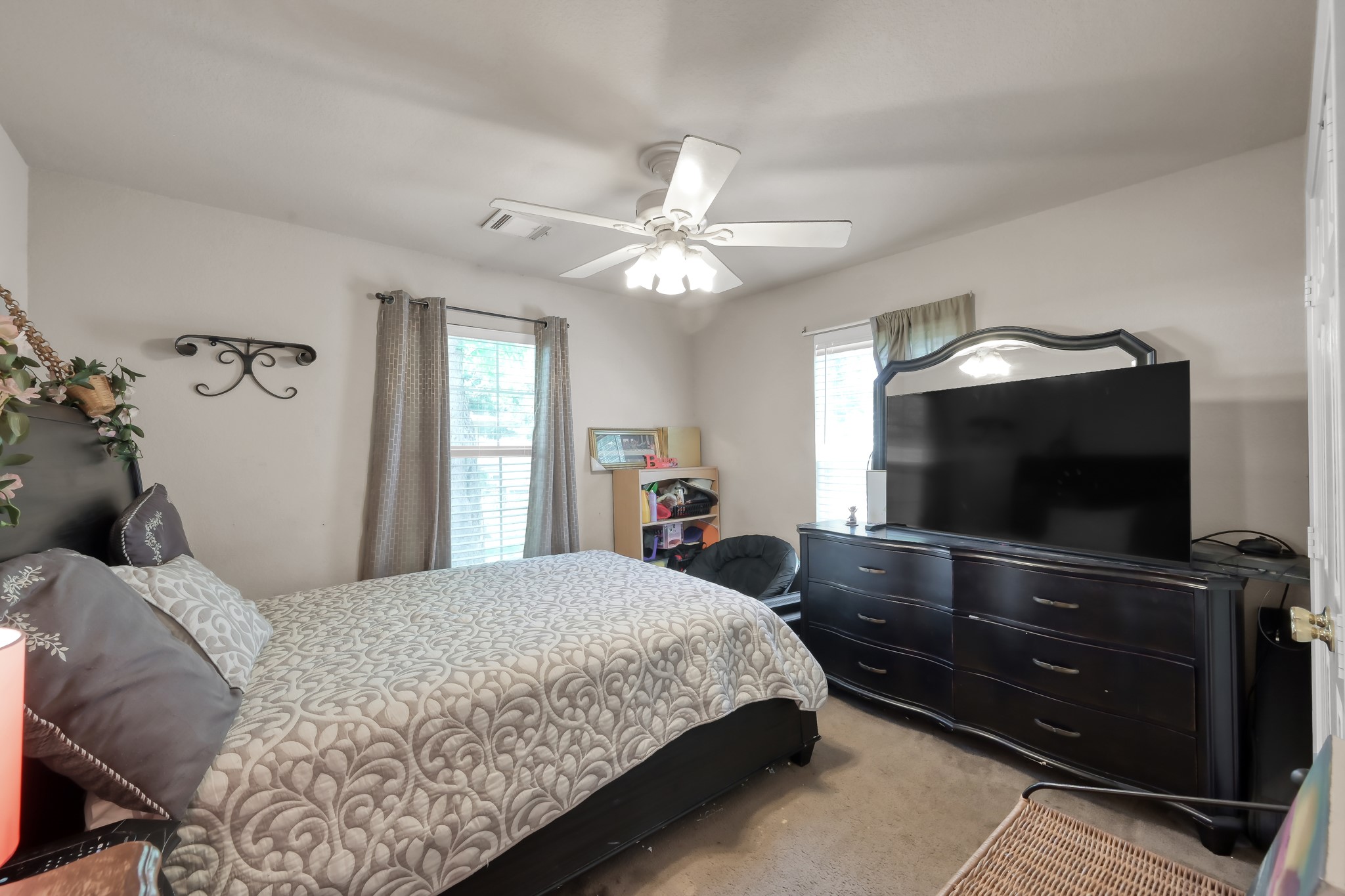 805 Webb Street Conroe, TX 77301 - Photo 13 of 19 a bedroom with a bed and a flat tv screen on dresser