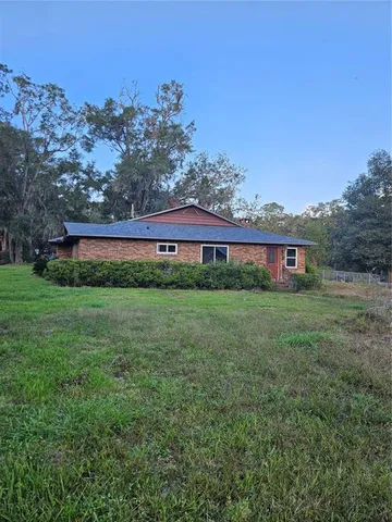a view of a house with large trees and a barn