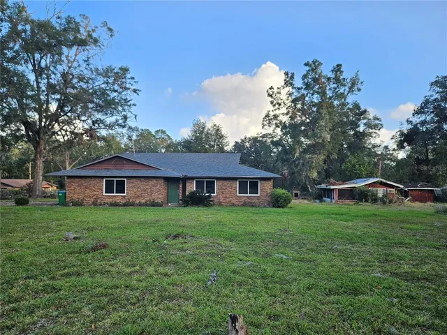a view of a big yard in front of a house with a large tree