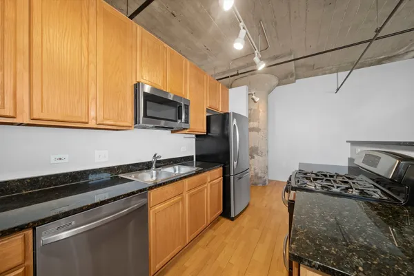a kitchen with stainless steel appliances granite countertop a sink stove and refrigerator
