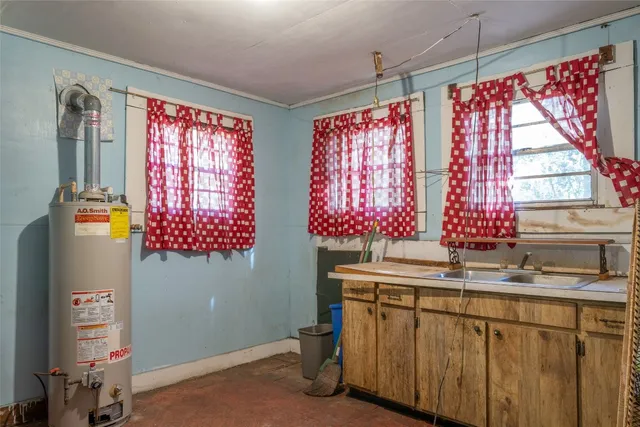 a view of a house with a yard and large trees