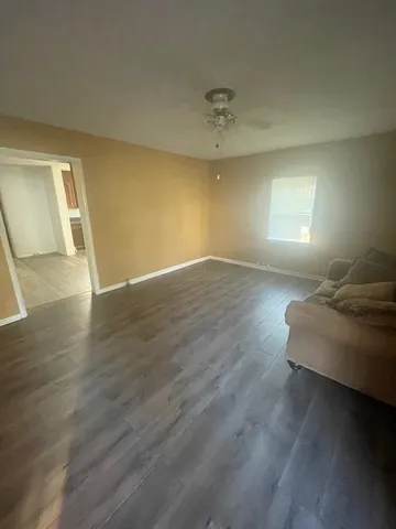 a view of a livingroom with wooden floor and a window