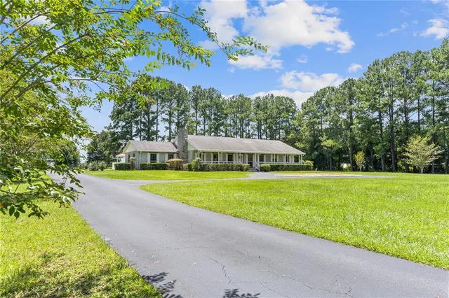 a view of a house with a yard and swimming pool