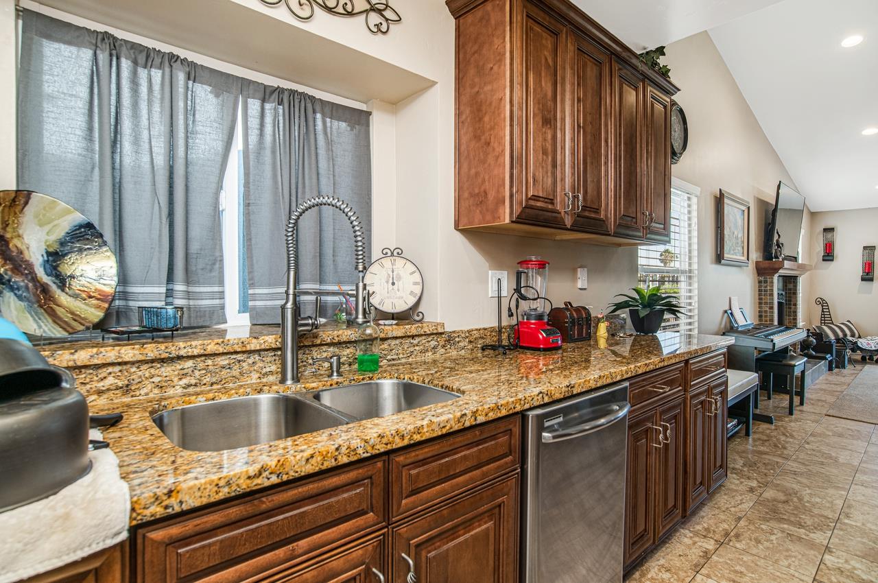 5644 Schooner Loop Discovery Bay, CA 94505 - Photo 14 of 42 a kitchen with stainless steel appliances granite countertop a sink dishwasher and cabinets with wooden floor