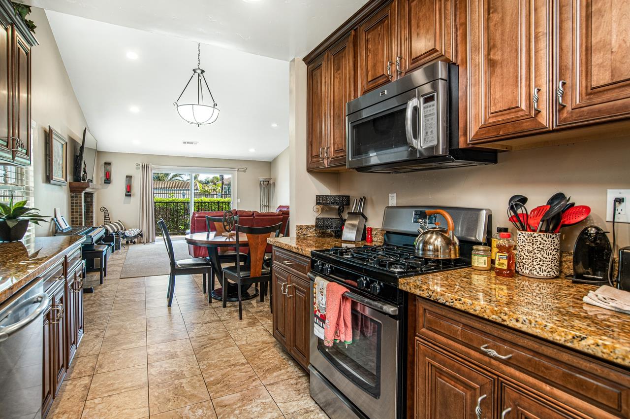 5644 Schooner Loop Discovery Bay, CA 94505 - Photo 15 of 42 a kitchen with stainless steel appliances granite countertop a stove a sink and a microwave