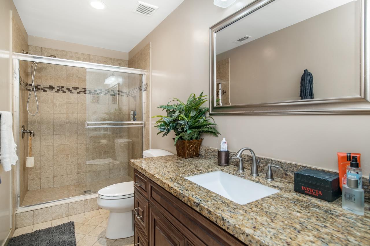 5644 Schooner Loop Discovery Bay, CA 94505 - Photo 23 of 42 a bathroom with a granite countertop sink a toilet and shower