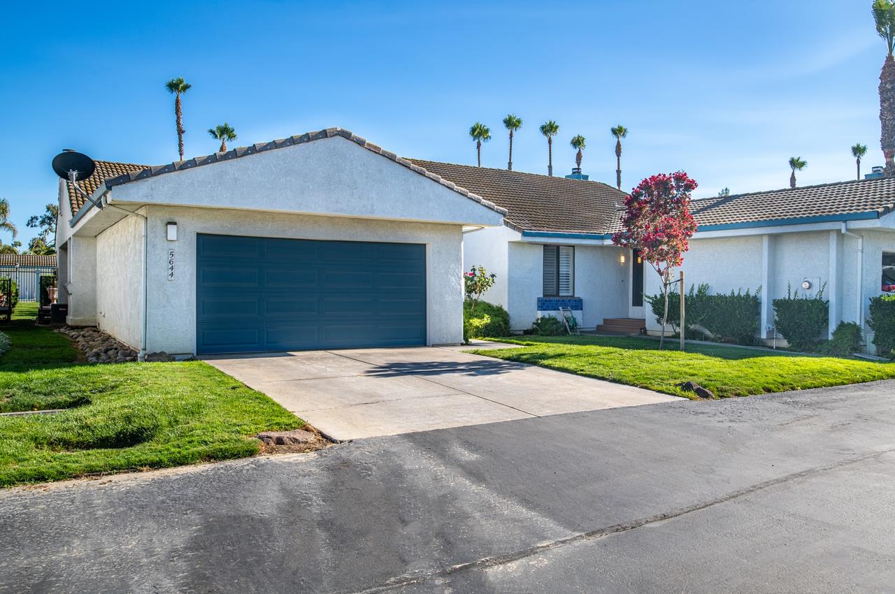 5644 Schooner Loop Discovery Bay, CA 94505 - Photo 4 of 42 a front view of yellow house with a yard and garage
