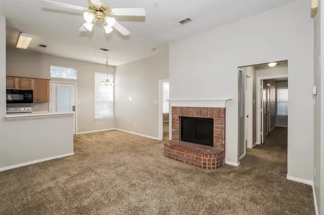 an empty room with windows and fireplace