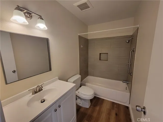 a bathroom with a bathtub shower sink vanity and toilet