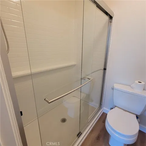 a white toilet sitting next to a shower