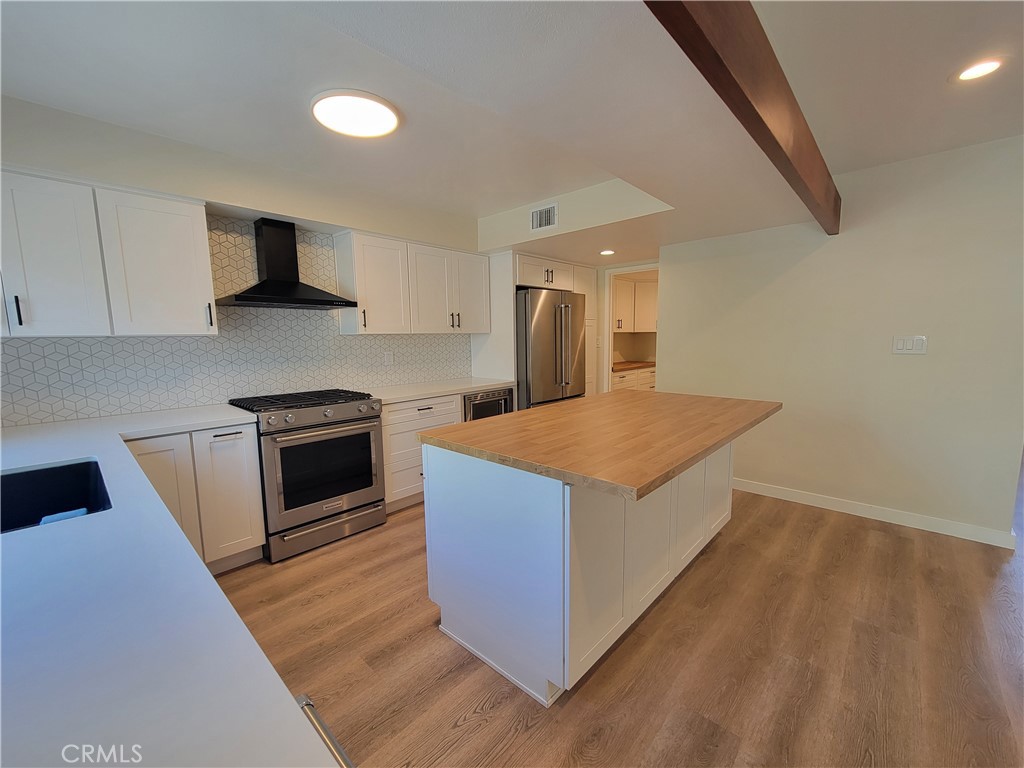11 Meadowsweet Way Irvine, CA 92612 - Photo 8 of 35 a kitchen with stainless steel appliances kitchen island granite countertop a stove a sink and a refrigerator