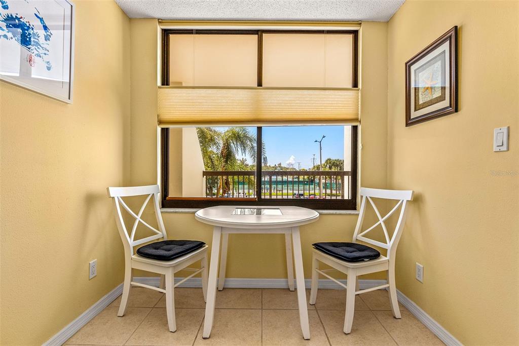 9495 Blind Pass Road, Unit 202 St. Pete Beach, FL 33706 - Photo 13 of 55 a dining room with furniture and a window