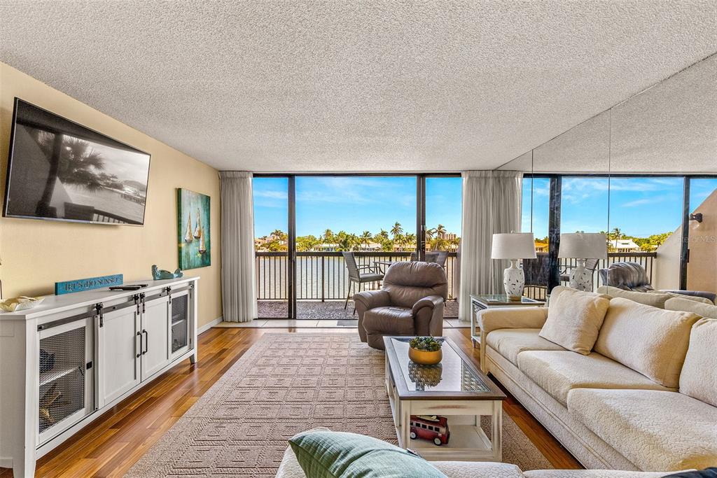 9495 Blind Pass Road, Unit 202 St. Pete Beach, FL 33706 - Photo 16 of 55 a living room with furniture and a large window