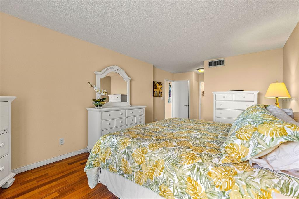9495 Blind Pass Road, Unit 202 St. Pete Beach, FL 33706 - Photo 18 of 55 a bedroom with a bed and a dresser