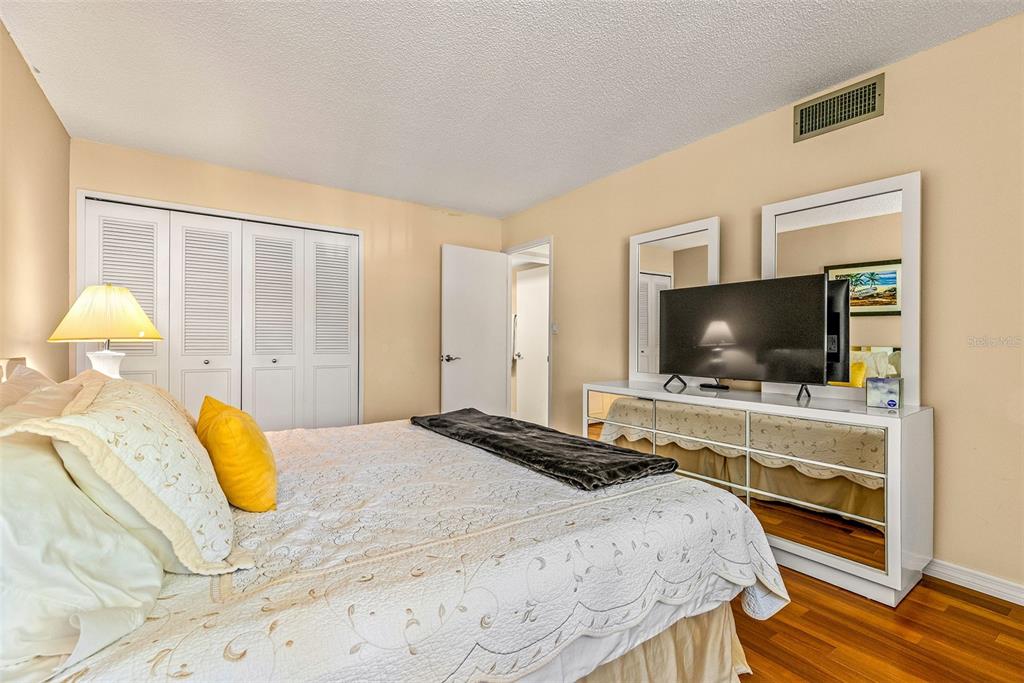 9495 Blind Pass Road, Unit 202 St. Pete Beach, FL 33706 - Photo 21 of 55 a bedroom with a bed and a flat screen tv