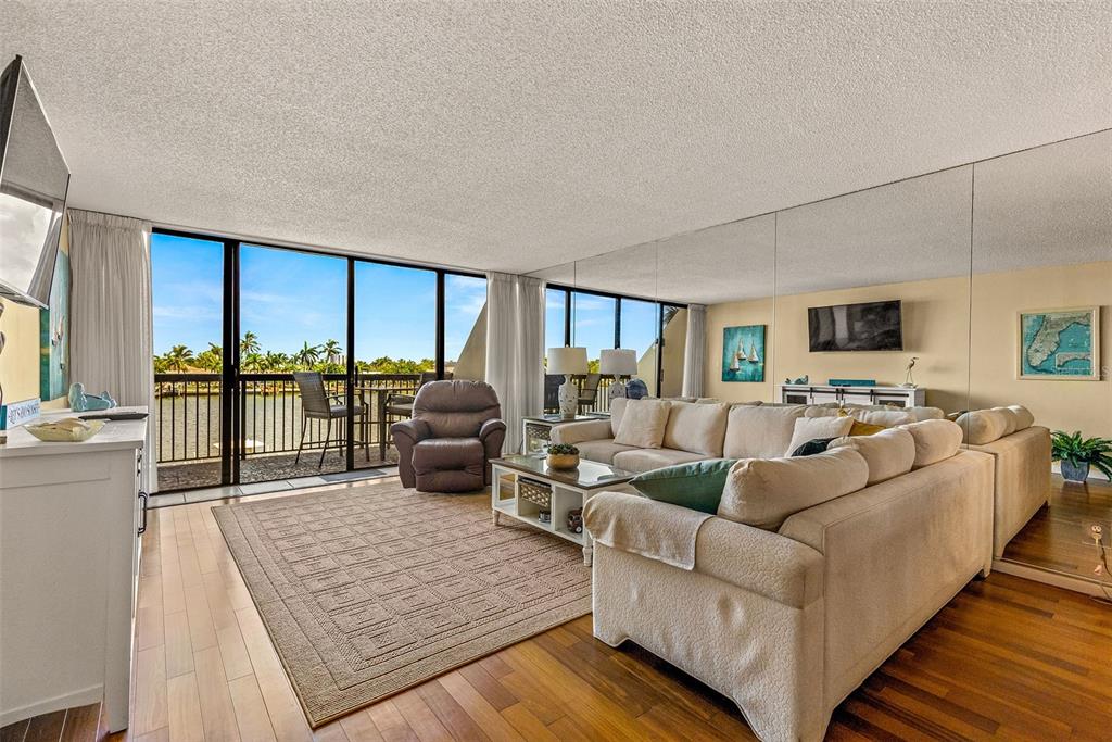 9495 Blind Pass Road, Unit 202 St. Pete Beach, FL 33706 - Photo 5 of 55 a living room with furniture floor to ceiling window and a table