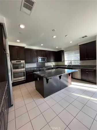a kitchen with stainless steel appliances kitchen island granite countertop a sink and cabinets