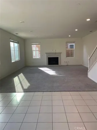 an empty room with kitchen view and window