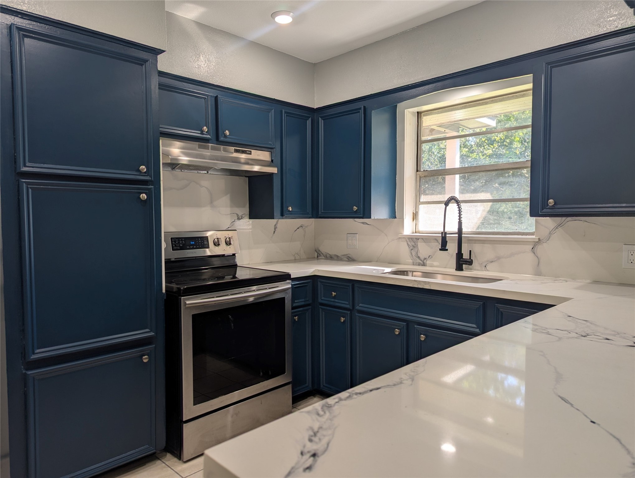 a kitchen with a sink appliances and cabinets