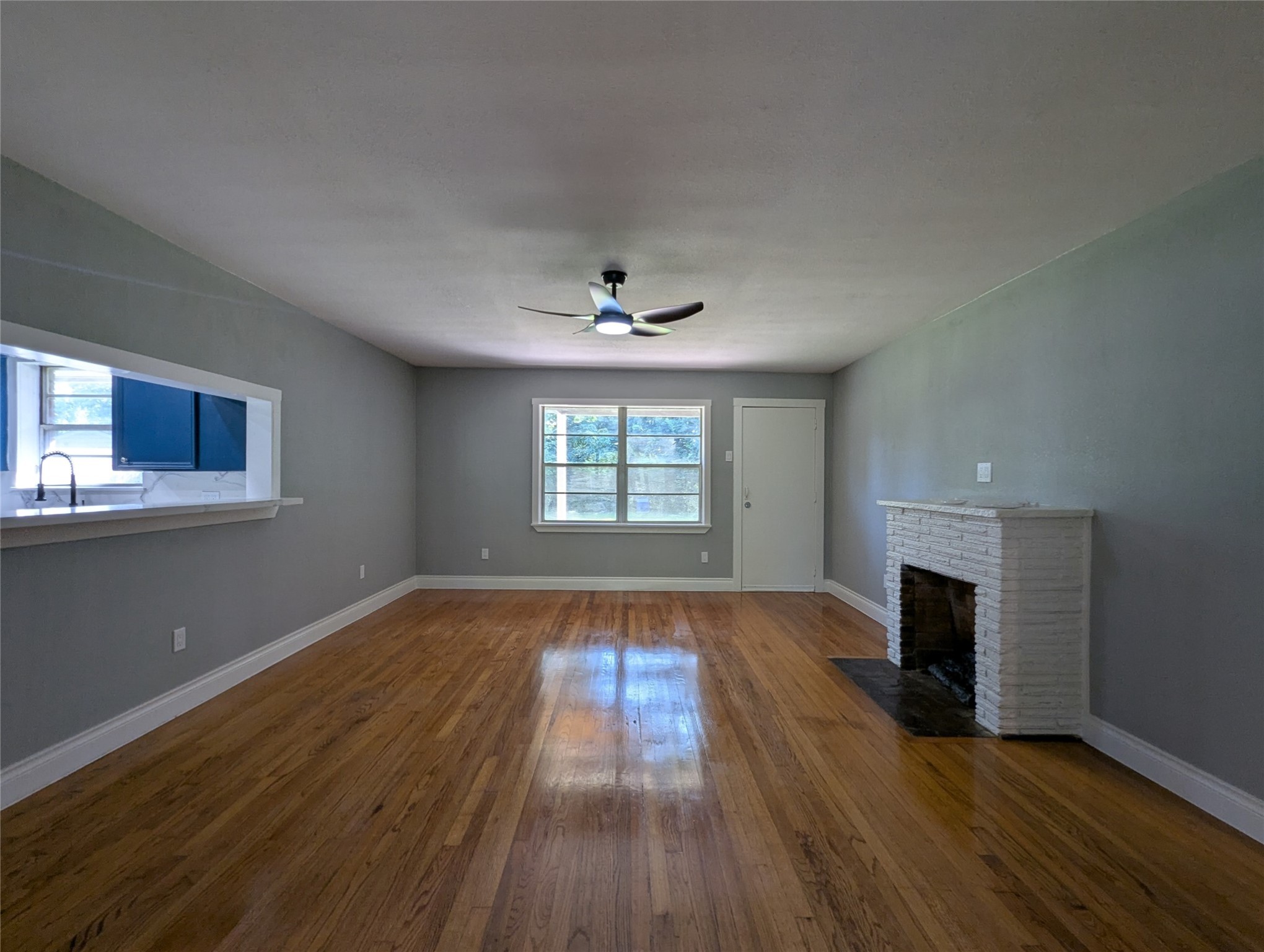 12633 Arp Street Houston, TX 77085 - Photo 6 of 11 an empty room with wooden floor fireplace and windows