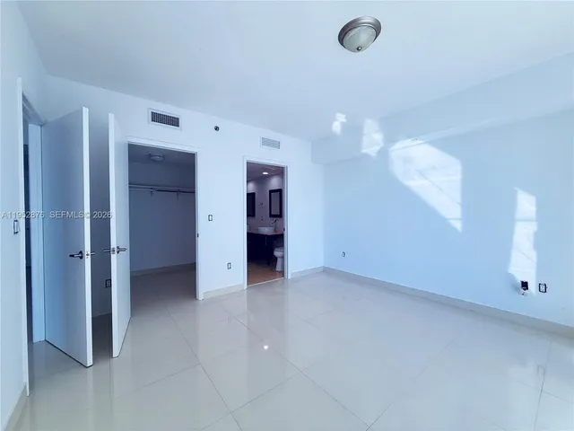 a spacious bathroom with a toilet sink and mirror