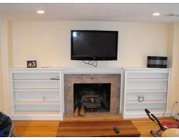126 Lowell Road Pepperell, MA 01463 - Photo 4 of 16 a living room with a fireplace and a flat screen tv