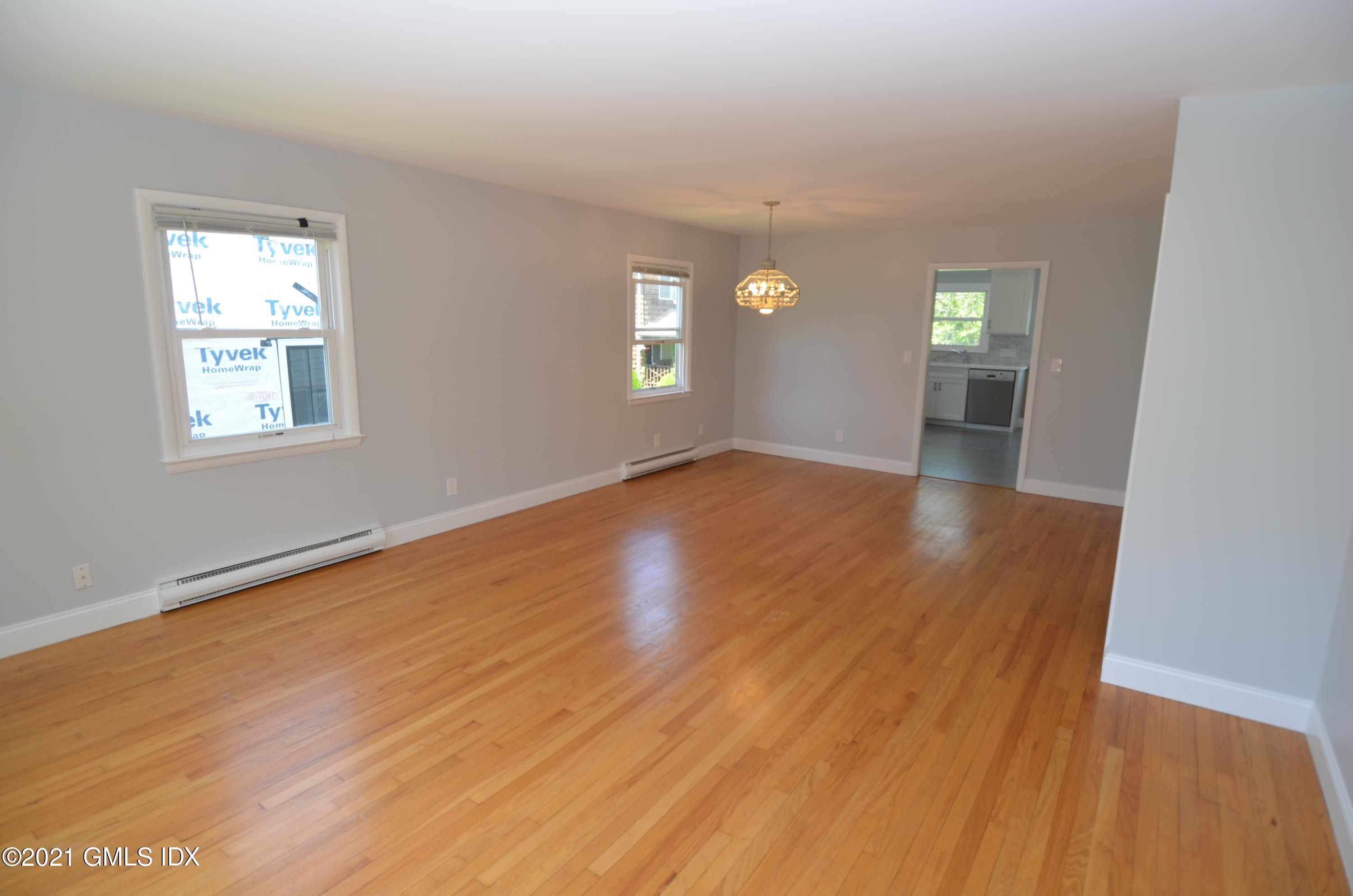5 Ridge Place, Unit 1 Greenwich, CT 06831 - Photo 4 of 29 an empty room with wooden floor and windows