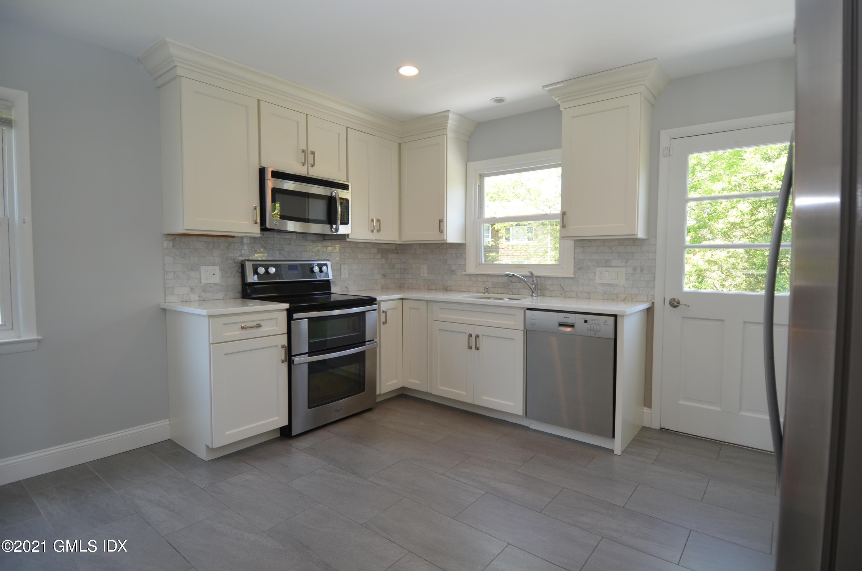 5 Ridge Place, Unit 1 Greenwich, CT 06831 - Photo 8 of 29 a kitchen with a sink white cabinets and white appliances