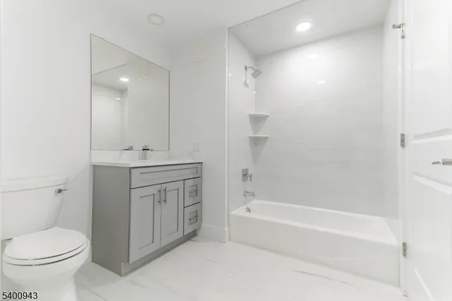 a bathroom with a granite countertop toilet a sink and bathtub