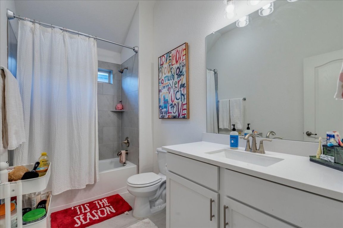 409 Durian Loop Buda, TX 78610 - Photo 20 of 30 Bathroom with shower / bath combo, vanity, and light tile patterned flooring