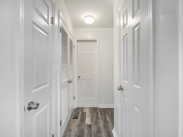 a view of a hallway with wooden floor