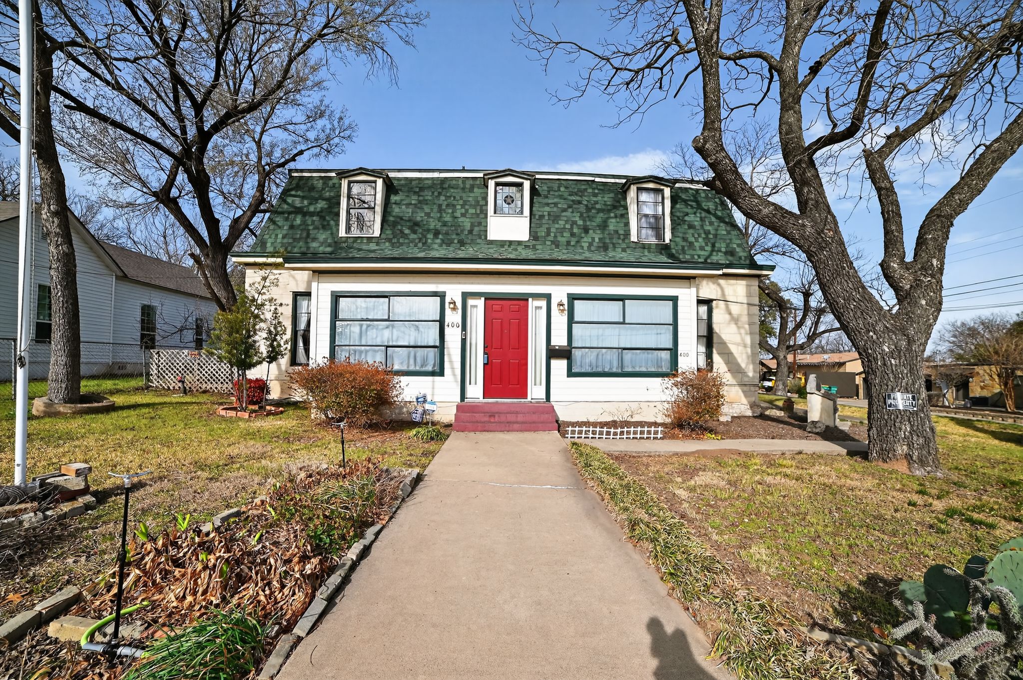 400 South Main Street Belton, TX 76513 - Photo 2 of 18 View of front of home featuring roof with shingles, a front yard, and mansard roof
