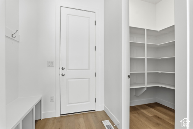 79 South Crimson Way West, Unit 307 Mapleton, UT 84664 - Photo 21 of 42 White interior door, built-in storage bench, and wood-finish flooring