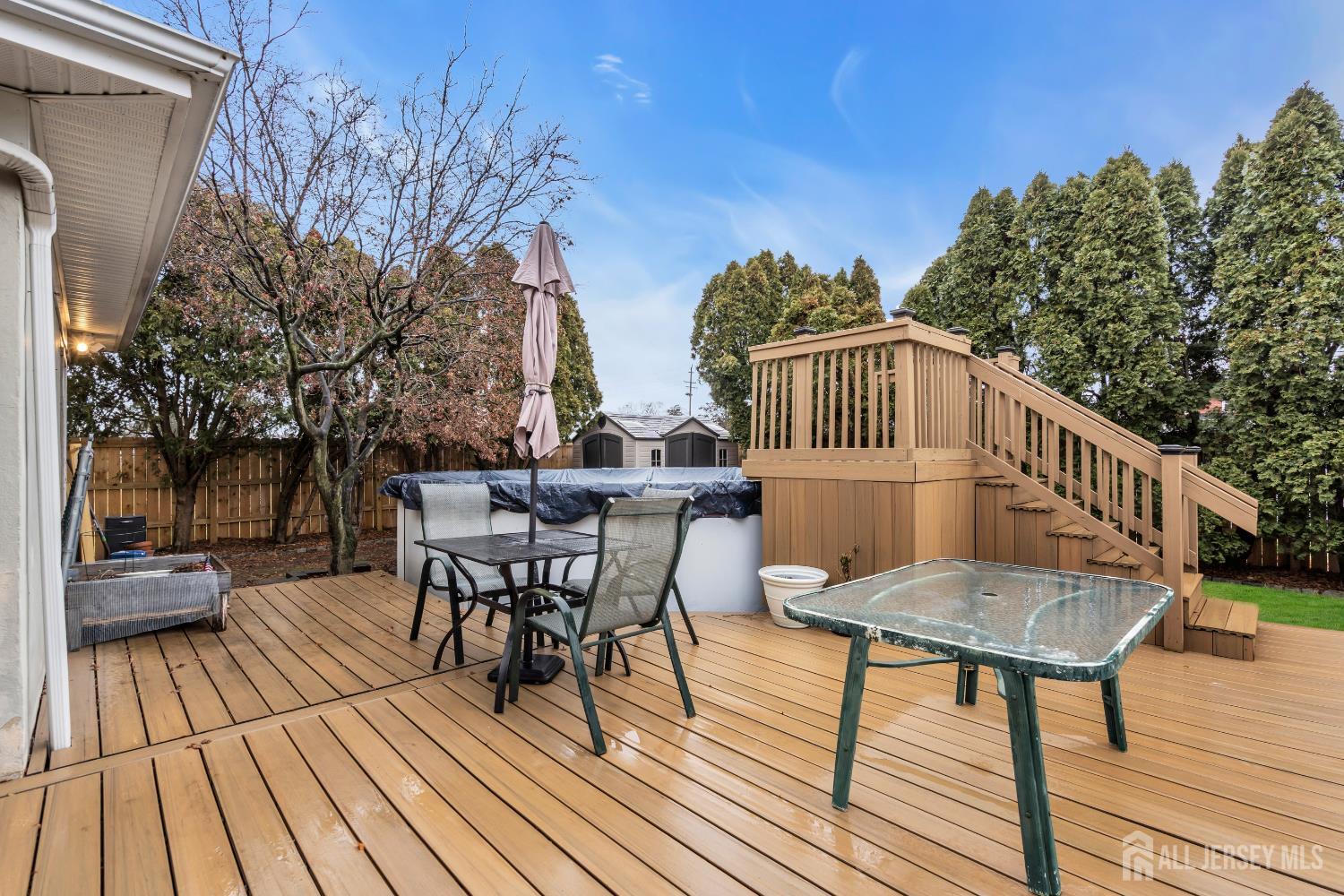 505 Summit Street Hightstown, NJ 08520 - Photo 25 of 30 a view of a roof deck with table and chairs with wooden floor and fence