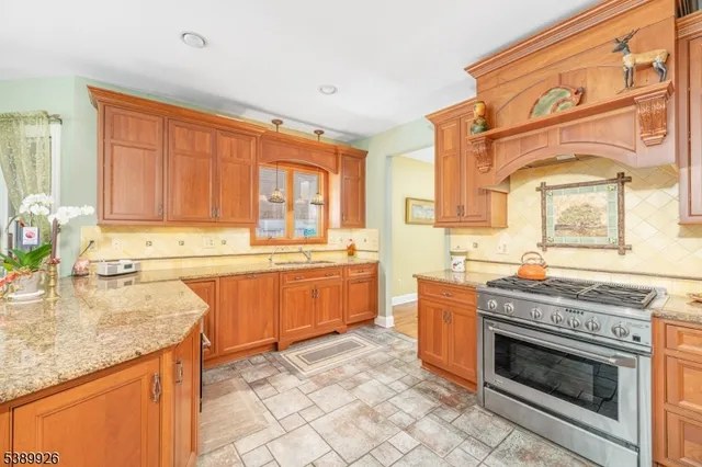 a kitchen with stainless steel appliances granite countertop a stove a sink and a refrigerator