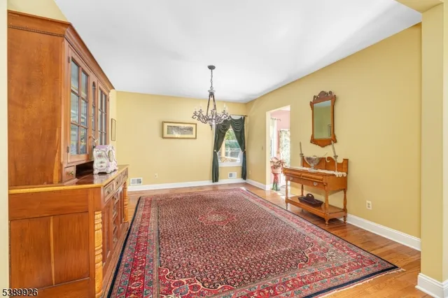 a living room with furniture a dining table and a chandelier