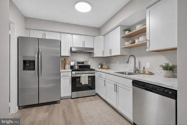 a kitchen with stainless steel appliances granite countertop a refrigerator sink and stove