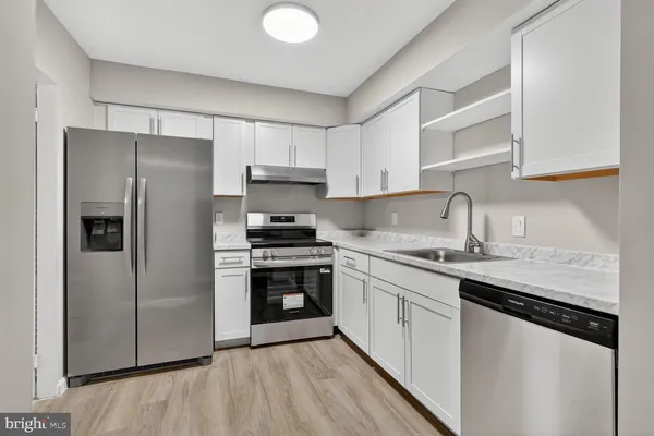 a kitchen with stainless steel appliances granite countertop a refrigerator sink and stove