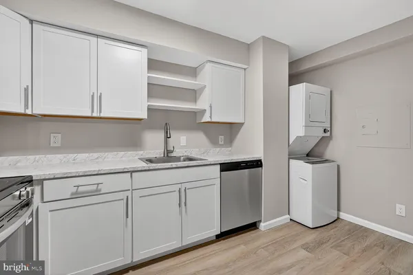 a kitchen with granite countertop white cabinets and a sink