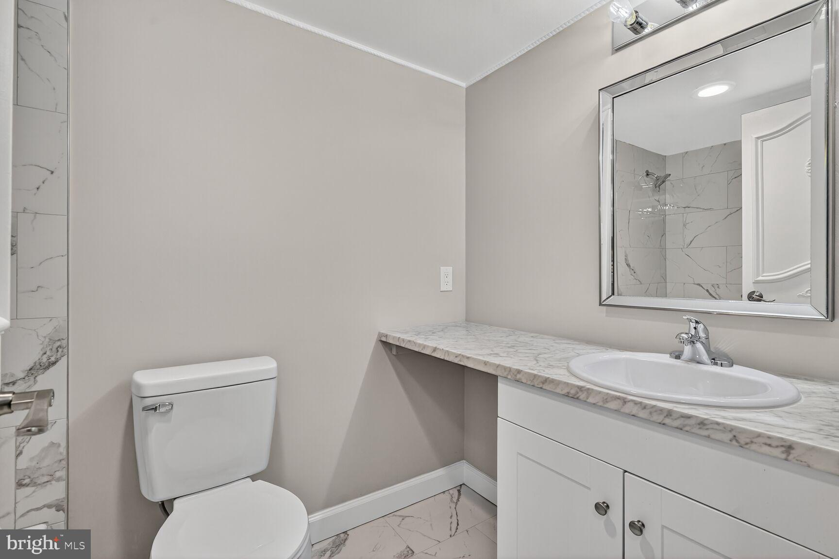 9200 Edwards Way, Unit 811 Hyattsville, MD 20783 - Photo 9 of 15 a bathroom with a granite countertop toilet sink and mirror