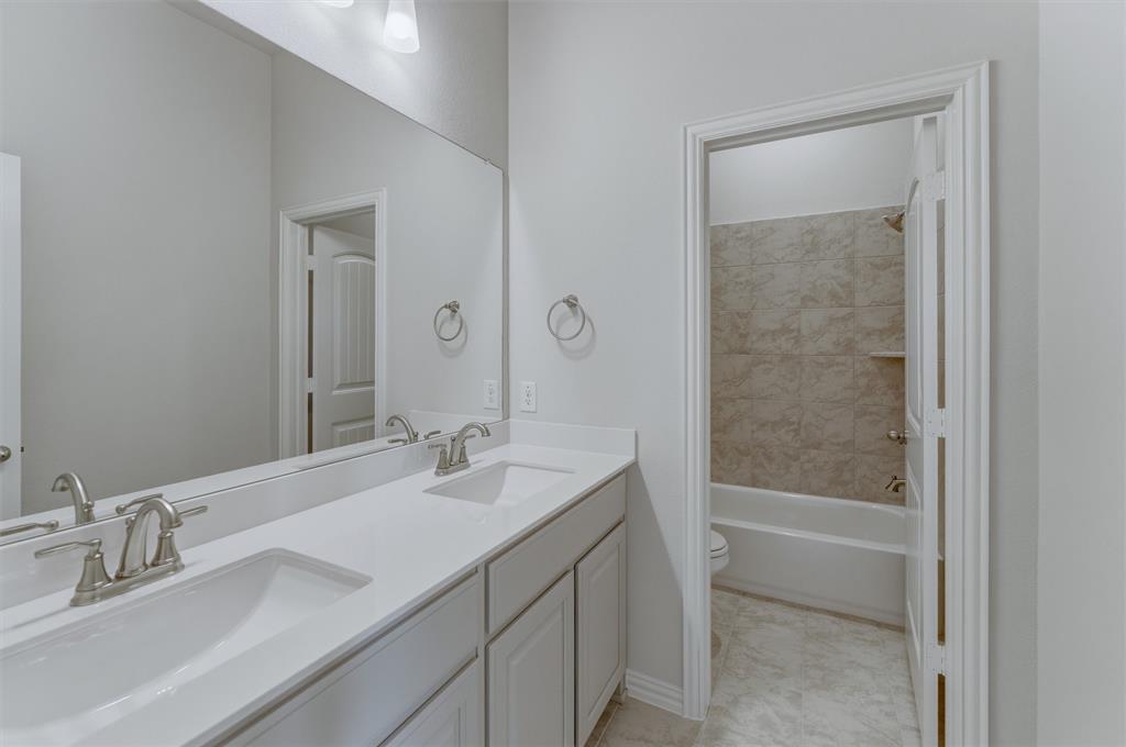 605 Tay Tay Way Springtown, TX 76082 - Photo 19 of 31 Modern bathroom with a dual vanity featuring white shaker-style cabinetry, white countertops, and brushed nickel faucets