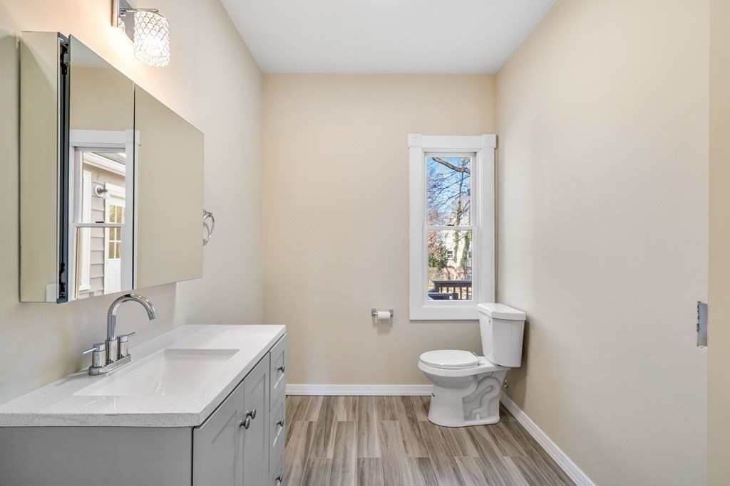 85 Barrows Street Dedham, MA 02026 - Photo 12 of 31 a bathroom with a toilet a sink and a mirror