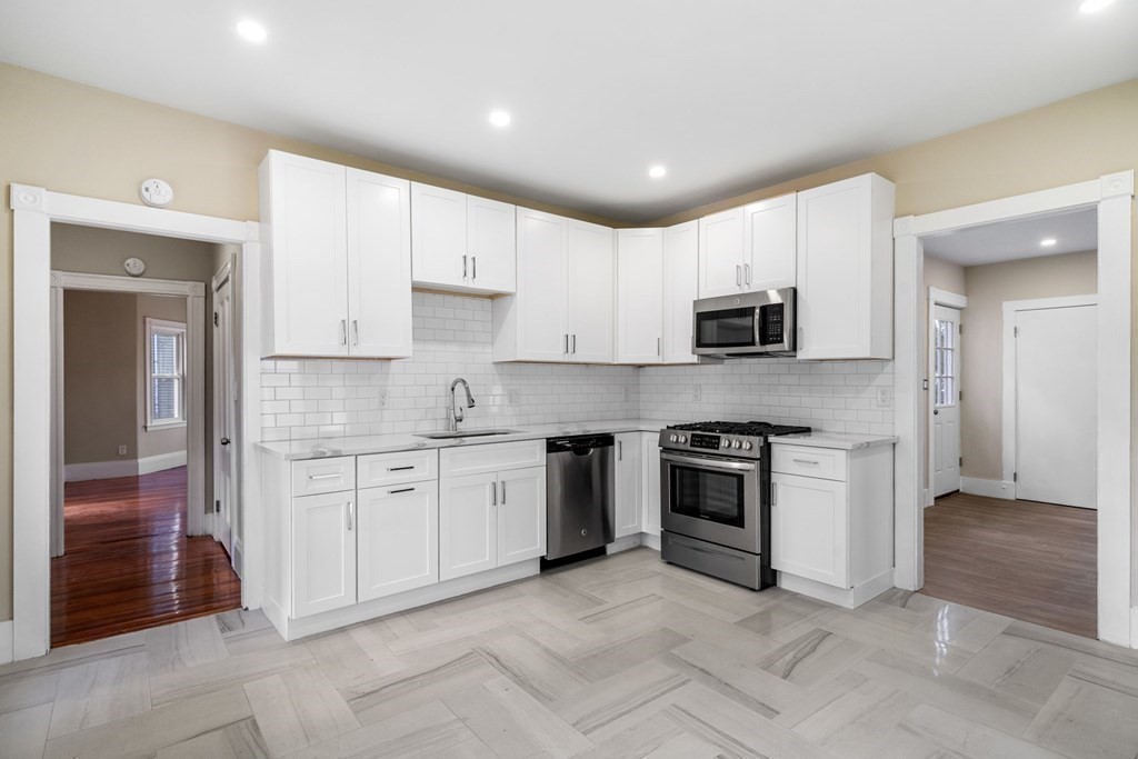 85 Barrows Street Dedham, MA 02026 - Photo 7 of 31 a kitchen with granite countertop white cabinets and stainless steel appliances