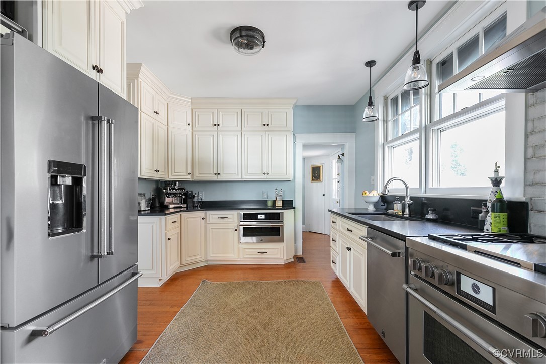 4222 Seminary Avenue Richmond, VA 23227 - Photo 25 of 50 a kitchen with stainless steel appliances granite countertop a refrigerator a sink dishwasher a stove and white countertops with wooden floor