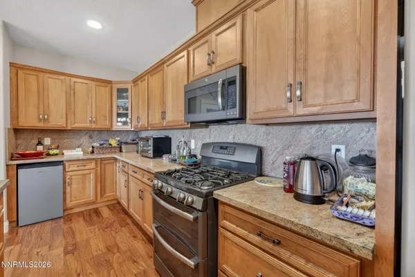 a kitchen with stainless steel appliances granite countertop a stove a sink and a white cabinets