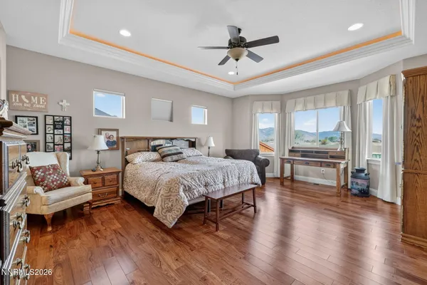 a spacious bedroom with a bed and wooden floor