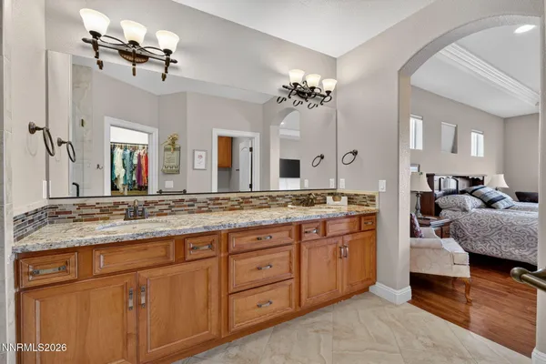 a spacious bathroom with a granite countertop double vanity and a mirror