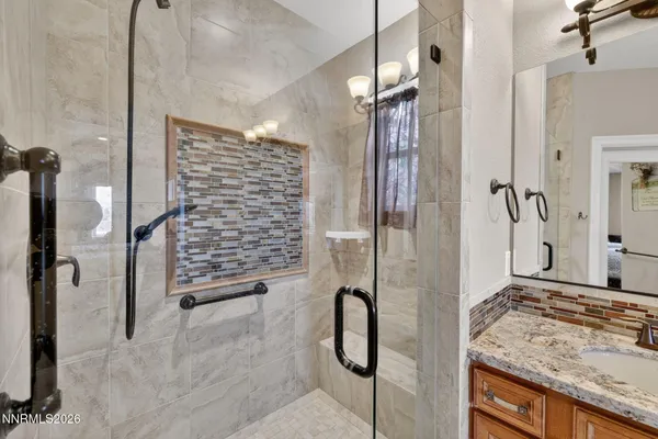 a bathroom with a granite countertop shower and a sink