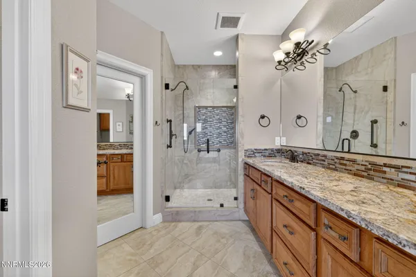a spacious bathroom with a granite countertop sink mirror and shower