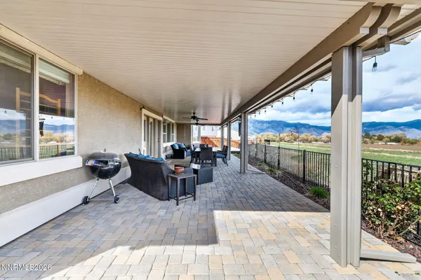 a view of a patio with table and chairs potted plants with wooden floor and fence
